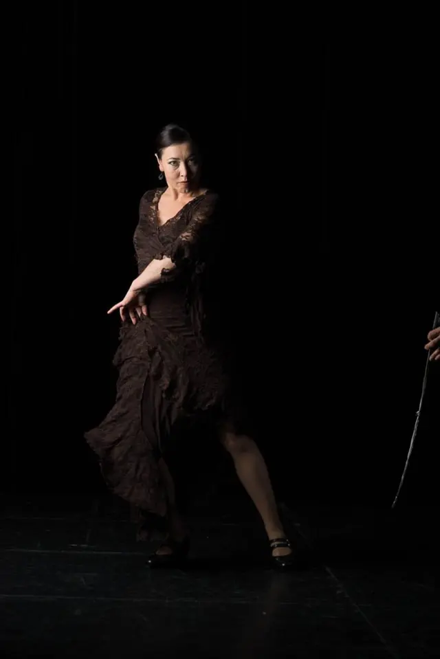 La Liz, flamenco teacher, dancing on a dark stage